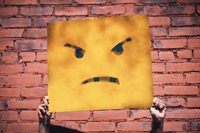 a frowning face on a placard which means an unsatisfied user/customer/web visitor