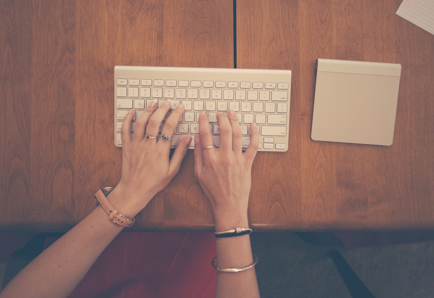 an image of a content writer typing away following Invesp’s guest posting guideline.