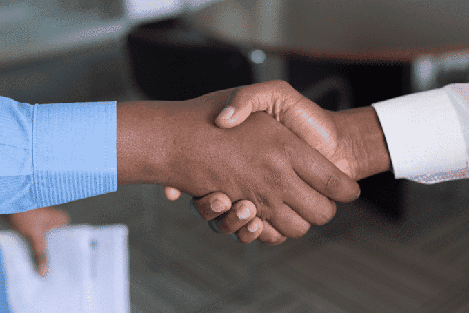 two conversion optimization experts shaking hands after achieving compliance that will improve client’s conversions